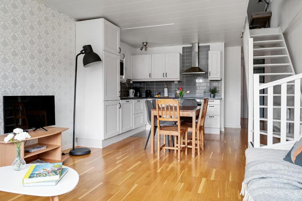 Open plan living area with kitchen and stairs to loft